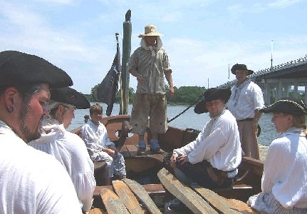Dutch at the prow of the long boat explaining rowing procecure