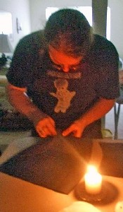 Michael Bagley sewing by candle-light