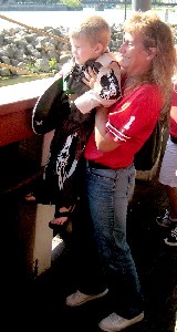 A woman holding her son up so he can see over the rail