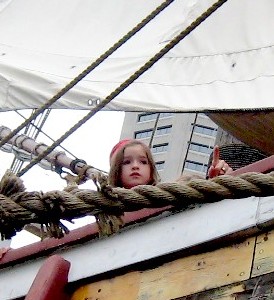 A little girl peering over the side of the Santa Maria