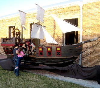Woman holding her kid up to the pirate on a ship