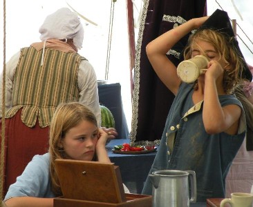 Boy drinking heartily while disgusted girl looks on