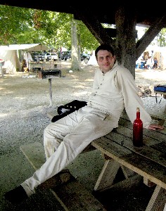 Guy with red bottle on picnic table