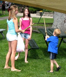 Two girls and boy sword fighting