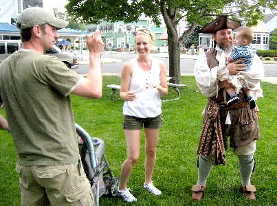 M.A. d'Dogge holding a couple's baby while they photograph him