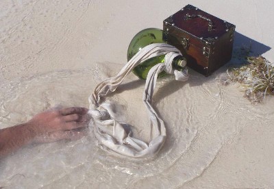A hand in the water reaching for an onion-skin bottle
