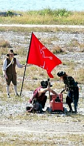 MIssion holding the flag while Bone Island buccaneers prep their cannon